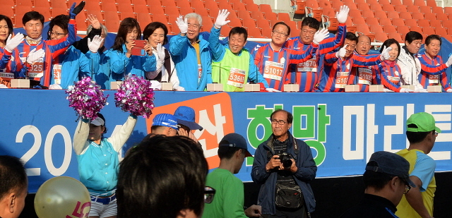 안산시와 경기일보가 공동주최한 2014 안산 희망 마라톤대회가 열린 9일 안산 와스타디움에서 제종길 안산시장, 성준모 안산시의회 의장, 이순국 경기일보 사장 등 내빈이 손을 흔들며 출발하는 마라토너를 격려하고 있다. 추상철기자