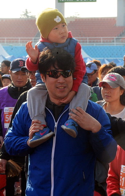 안산시와 경기일보가 공동주최한 2014 안산 희망 마라톤대회가 열린 9일 안산 와스타디움에서 아이와 함께 5km 부문에 출전한 참가자가 출발선을 나서고 있다. 추상철기자