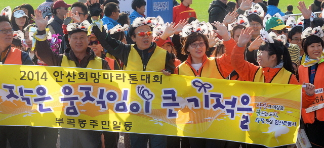 안산시와 경기일보가 공동주최한 2014 안산 희망 마라톤대회가 열린 9일 안산 와스타디움에서 이색복장을 한 5km 부문 참가자들이 손을 흔들며 출발선을 나서고 있다. 추상철기자