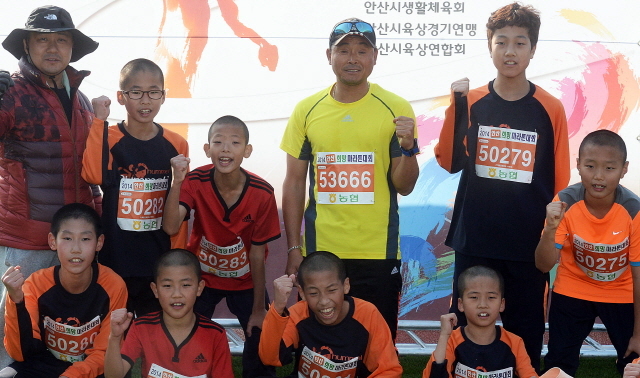 안산시와 경기일보가 공동주최한 2014 안산 희망 마라톤대회가 열린 9일 안산 와스타디움에서 국민 마라토너 이봉주선수가 참가자들과 함께 기념촬영을 하고 있다 . 추상철기자