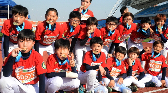 안산시와 경기일보가 공동주최한 2014 안산 희망 마라톤대회가 열린 9일 안산 와스타디움에서 5km부문에 완주한 초등학교 학생들이 완주메달을 들어보이며 기념촬영을 하고 있다. 추상철기자