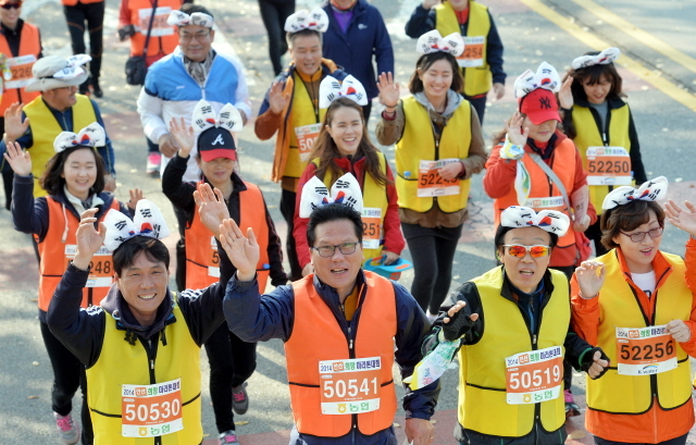 9일 안산 와스타디움에서 열린 '2014 안산 희망 마라톤대회'에서 안산 부곡동주민센터 직원들이 단체로 태극기 머리띠를 착용한 채 달리고 있다. 안산시와 경기일보가 주최한 이번 행사는 마라토너와 자원봉사자 등 1만여명이 함께했다. 김시범기자