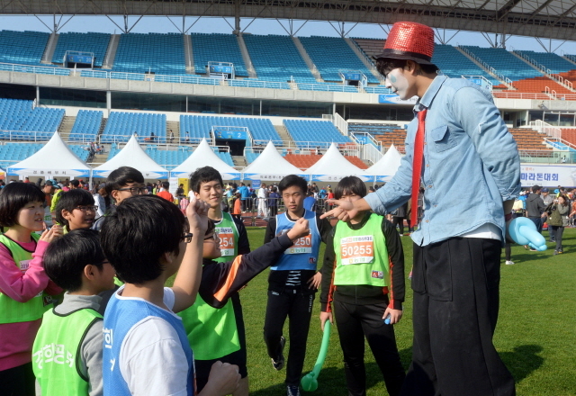 9일 안산 와스타디움에서 열린 '2014 안산 희망 마라톤대회'에서 키다리 삐에로가 아이들에게 풍선을 나눠주고 있다. 안산시와 경기일보가 주최한 이번 행사는 마라토너와 자원봉사자 등 1만여명이 함께했다. 김시범기자