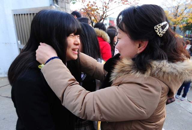 2015학년도 대학수학능력 시험일인 13일  인천시 교육청 제27시험장인 남구 학익여고 교문 앞에서 한 교사가 수험생의 얼굴을 안아주며 응원을 해주고 있다. 장용준기자