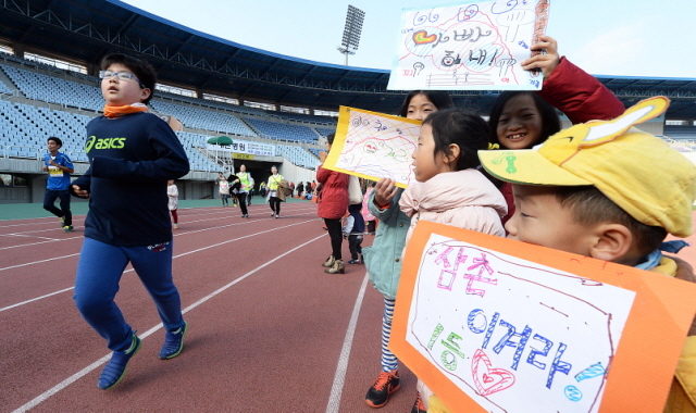 부천시와 경기일보가 공동주최한 제9회 부천복사골마라톤대회가 열린 16일 부천종합운동장에서 어린이들이 마라톤에 참가한 아빠와 삼촌을 응원하고 있다. 추상철기자