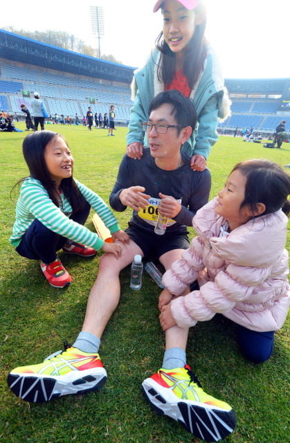 부천시와 경기일보가 공동주최한 제9회 부천복사골마라톤대회가 열린 16일 부천종합운동장에서 한 참가자 자녀들이 완주한 아빠의 어깨와 다리를 안마해 주고 있다. 추상철기자