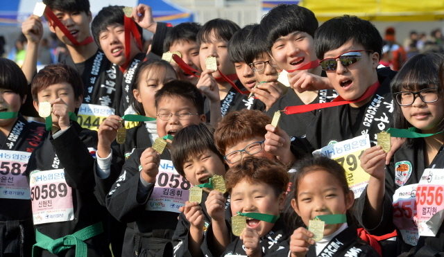 부천시와 경기일보가 공동주최한 제9회 부천복사골마라톤대회가 열린 16일 부천종합운동장에서 합기도 수련 학생들이 도복을 입고 완주 메달을 들어보이고 있다. 추상철기자