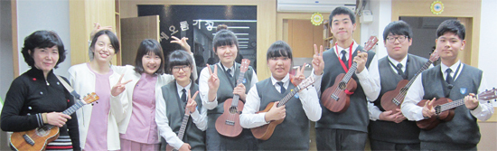 ▲ 광명 광문고등학교 우쿨렐레 동아리 학생과 박애경 지도교사(왼쪽)가 최근 시흥시에 소재한 새오름 호스피스병원을 찾아 환자 및 간호사를 관객으로 감동의 연주를 펼친 뒤 기념촬영을 하고 있다.