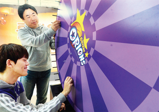 ▲ 표적을 던져 꽂힌 부분에 표시된 선물을 주는 경품 이벤트에 사용될 룰렛판을 크리에이터 단원과 함께 점검하고 있다.