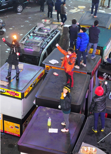 27일 오전 인천시 남동구 로데오거리 광장에서 구청의 불법노점 행정대집행에 반발한 노점 상인들이 노점지붕에 올라가 대치하고 있다. 장용준기자