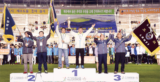 ▲ 제95회 전국체육대회 시상식에서 종합우승 13연패를 달성한 경기도 선수단 이태영 사무처장 등이 시상대 가장 높은 곳에 올라 우승기와 우승트로피를 들어 보이고 있다