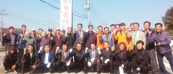 ▲ 여주복숭아 홍보탑에서 기념 촬영을 하고 있는 복숭아연구회 회원들.