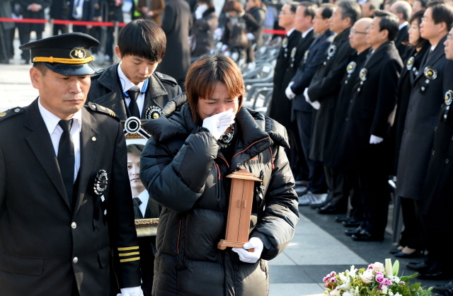 27일 오후 인천시 남동구 인천시청 앞 미래광장에서 세월호 참사 일반인 희생자 합동영결식을 마친 유족들이 오열하며 고인의 영정을 들고 인천가족공원으로 향하고 있다. 장용준기자