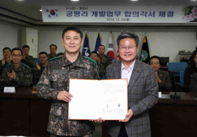 ▲ 채인석 화성시장과 김일수 51사단장이 29일 51사단에서 궁평리 해송군락지 일원 군 철조망을 제거하는 내용이 담긴 합의각서를 체결한 뒤 기념촬영을 하고 있다.  화성시 제공