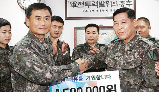 ▲ 수도군단 주임원사 도한철 원사가 8일 권석기 원사(오른쪽)에게 모금액을 전달하고 있다.