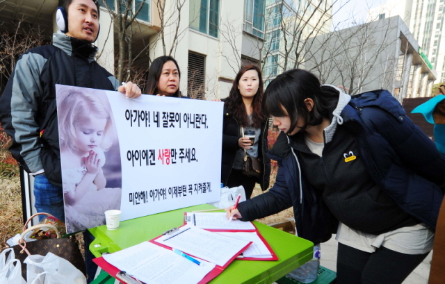 15일 오전 인천시 송도국제도시 입주민연합회 소속 학부모가 원아폭행 사건이 발생한 어린이집 인근에서 사건 재발 방지 대책을 촉구하는 1인 시위와 함께 서명을 받고 있다. 장용준기자