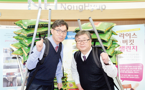 ▲ 오경석 농협중앙회 경기지역본부장(오른쪽)과 이대훈 영업본부장이 26일 지역본부 로비에서 전국 쪽방촌 주민들을 돕기위해 릴레이로 펼치는 라이스버킷 챌린지에 동참하고 있다.  김시범기자