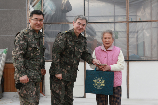 ▲ 육군 제26사단 준사관단이 6·25 참전용사 미망인 강명자 할머니를 찾아 위문품을 전달하고 있다.