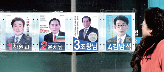 ▲ 제1회 전국동시조합장 선거를 하루 앞둔 10일 오후 한 유권자가 인천시 남동구 인천수협 간석동 지점 정문에 부착된 후보자 포스터를 살펴보고 있다. 장용준기자