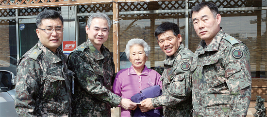 ▲ 육군 제26사단 준부사관단이 625 참전용사 미망인인 강명자 할머니(가운데)께 위로금을 전달하고 있다.