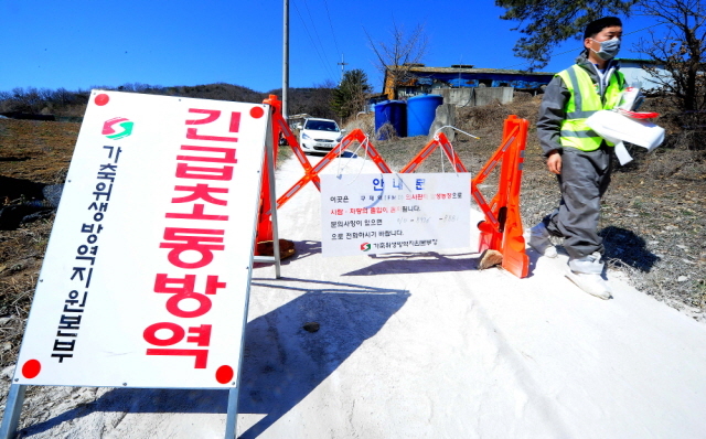 ▲ 24일 오후 4년만의 구제역이 발생한 인천시 강화군 화도면의 한 양돈농장 입구에서 긴급방역 조치에 나선 가축위생방역지원본부 직원들이 농장출입을 통제하고 있다. 장용준기자