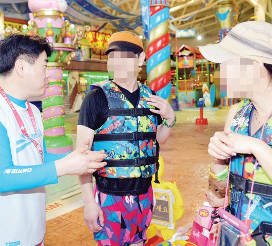 ▲ 워터파크를 찾은 가족에게 이용시 불편한 점이 없는지 물어보고 있다. 라이프가드의 역할 중 하다.