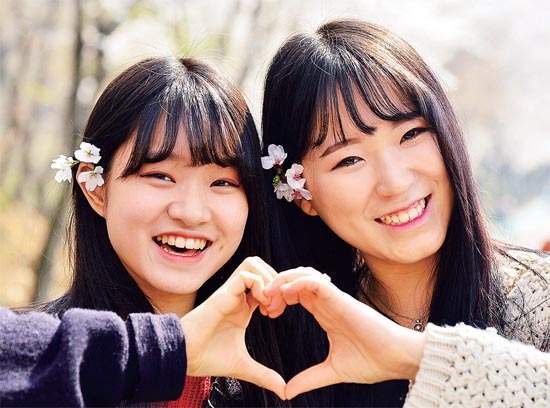 ▲ 온가족이 화창한 날씨속에 만개한 벚꽃을 만끽하며 걷고 있다.참가자들이 걷는 도중 벚꽃을 머리에 꽂은채 포즈를 취하고 있다.