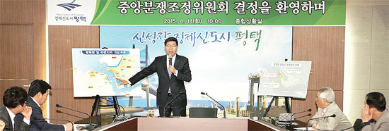 ▲ 공재광 평택시장(가운데)이 14일 열린 기자회견장에서 평택항 및 주변지역 개발 계획도를 가리키며 행정자치부의 평택당진항 신생 매립지 귀속 의결에 대한 찬성의사를 발표하고 있다.