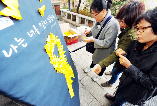 ▲ 세월호 참사 1주기인 16일 오전 추모미사가 열린 인천시 중구 답동성당에서 신자들이 미사에 앞서 노랑나비로 추모리본을 만들고 있다. 장용준기자