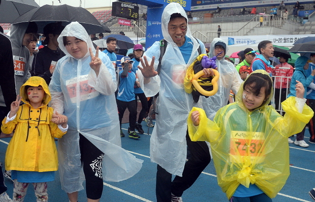 경기도와 수원시, 화성시, 경기일보가 공동주최한 제13회 경기마라톤대회가 열린 19일 수원종합운동장에서 가족단위의 참가자들이 출발선을 나서며 환하게 웃고 있다. 추상철기자