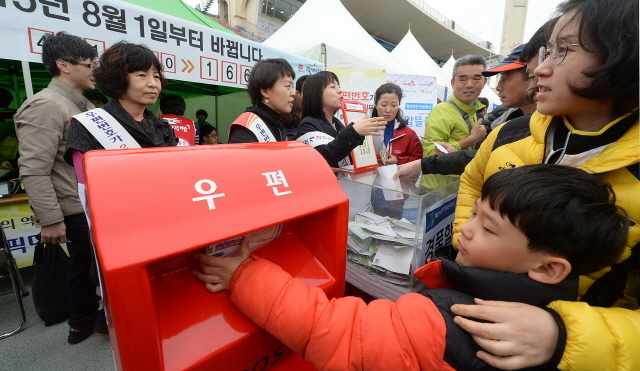경기도와 수원시, 화성시, 경기일보가 공동주최한 제13회 경기마라톤대회가 열린 19일 수원종합운동장에서 참가자들이 경인지방우정청 부스 체험을 하고 있다.  추상철기자