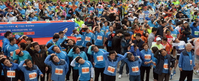 경기도와 수원시, 화성시, 경기일보가 공동주최한 제13회 경기마라톤대회가 열린 19일 수원종합운동장에서 남경필 경기지사와 강득구 경기도의회 의장, 염태영 수원시장, 채인석 화성시장, 신선철 경기일보 대표이사 회장, 국회의원 등 내빈들이 각 부문별 참가자들과 함께 몸풀기 체조를 하고 있다. 추상철기자
