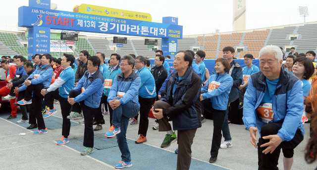 ▲ 경기도와 수원시, 화성시, 경기일보가 공동주최한 제13회 경기마라톤대회가 열린 19일 수원종합운동장에서 남경필 경기지사와 강득구 경기도의회 의장, 염태영 수원시장, 채인석 화성시장, 신선철 경기일보 대표이사 회장, 국회의원 등 내빈들이 몸풀기 체조를 하고 있다. 추상철기자