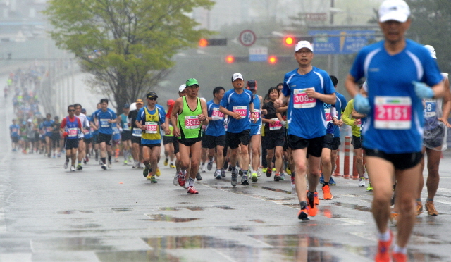 19일 오전 봄비속에 열린 제13회 경기마라톤에 참가한 하프코스 선수들이 성균관대 고가도로를 내려와 첫 반환점인 상구운 지하차도를 향해 힘차게 발걸음을 내딛고 있다. 장용준기자