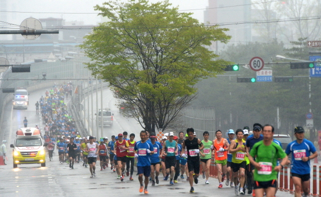 19일 오전 봄비속에 열린 제13회 경기마라톤에 참가한 하프코스 선수들이 성균관대 고가도로를 내려와 첫 반환점인 상구운 지하차도를 향해 힘차게 발걸음을 내딛고 있다. 장용준기자