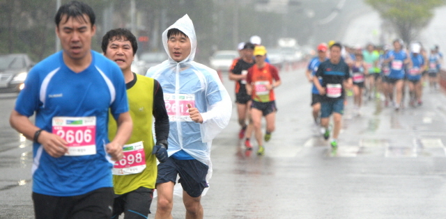 19일 오전  제13회 경기마라톤에 참가한 하프코스 선수들이 쏟아져 내리는 봄비를 맞으며  첫 반환점인 상구운 지하차도를 향해 힘차게 발걸음을 내딛고 있다. 장용준기자