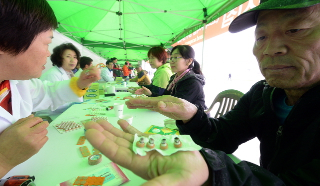 경기도와 수원시, 화성시, 경기일보가 공동주최한 제13회 경기마라톤대회가 열린 19일 수원종합운동장에서 참가자들이 고려수지침 부스에서 수지침을 받고 있다. 추상철기자