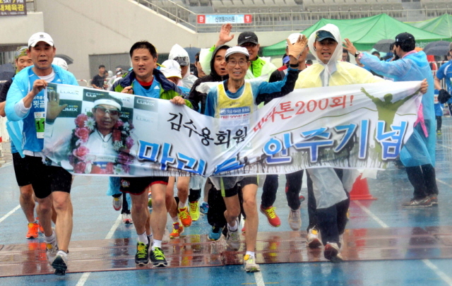 19일 수원 종합운동장에서 열린 제13회 경기마라톤대회에서 마라톤 200회에 출전한 김수용 마라토너가 동료들과 기쁨을 함께하며 결승선을 통과하고 있다. 전형민기자