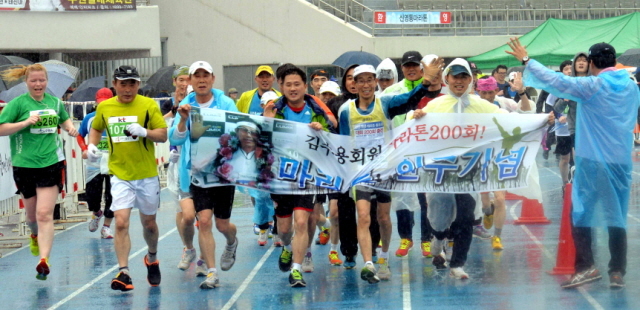 19일 수원 종합운동장에서 열린 제13회 경기마라톤대회에서 마라톤 200회에 출전한 김수용 마라토너가 동료들과 기쁨을 함께하며 결승선을 통과하고 있다. 전형민기자