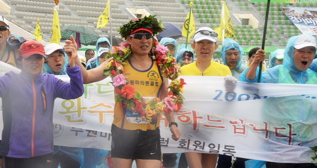 경기도와 수원시, 화성시, 경기일보가 공동주최한 제13회 경기마라톤대회가 열린 19일 수원종합운동장에서 100회 마라톤 완주자가 결승선을 통과하고 있다. 추상철기자