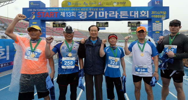경기도와 수원시, 화성시, 경기일보가 공동주최한 제13회 경기마라톤대회가 열린 19일 수원종합운동장에서 신선철 경기일보 대표이사 회장이 끝까지 포기하지 않고 완주한 마지막 참가자을 격려한 후 기념촬영을 하고 있다. 추상철기자