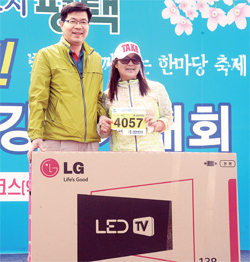 ▲ 4월 11일 ‘2015 평택 시민 건강걷기대회’가 열린 평택 이충레포츠공원에서 공재광 평택시장이 1등 경품 당첨자에게 LED TV를 전달하고 있다
