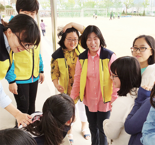 ▲ 인천 청람중학교 ‘117 학부모 패트롤’ 소속 학부모들이 점심 시간에 학교 운동장을 순찰하며 학생들에게 학교폭력 예방의 중요성을 설명하고 있다. 인천 청람중 제공