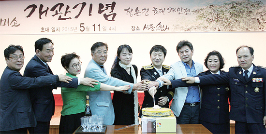 ▲ 시흥소방서 내 미소갤러리 개관전에 참석한 신종훈 서장(오른쪽 네 번째)과 정은경 화백 등 내빈들이 떡 케이트 절단식을 하고 있다.