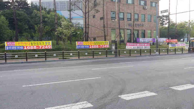 ▲ 화성 동탄신도시내 분양을 홍보하는 불법 플래카드가 차도를 따라 걸려있어 미관을 해치고 있다.  ♣♣강인묵기자