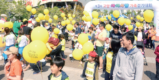 ▲ 고양시와 경기일보가 공동주관한 ‘제3회 고양 아이사랑 가족 걷기대회’에서 1천여명의 참가가족들이 푸르름과 꽃이 가득한 호수공원을 걷고 있다
