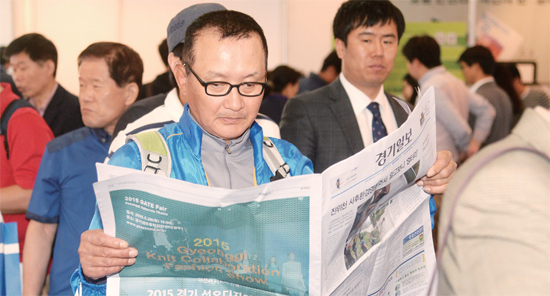 ▲ ‘2015 신문ㆍ뉴미디어 엑스포’ 행사장을 찾은 한 관람객이 홍보부스에 비치된 경기일보 신문지면을 읽고 있다. 엑스포에는 지방지로서는 경기일보와 부산일보만 참여했다