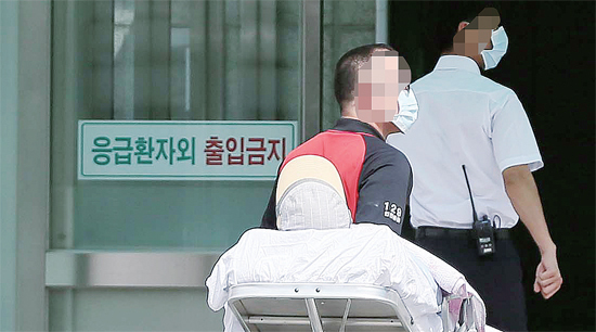 ▲ 경기도에서 발생한 중동호흡기증후군(메르스) 확진 환자가 주변 병원의 격리병동 만실로 인천의 한 대학병원으로 이송됐다고 밝혀진 2일 마스크 차림의 병원 관계자들이 응급실로 한 환자를 이송하고 있다.  장용준기자