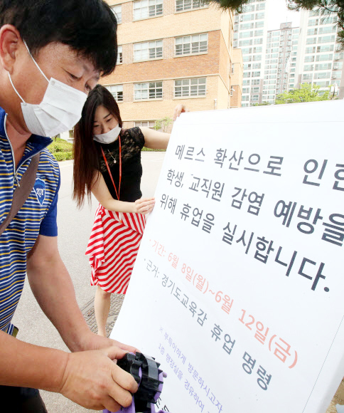 ▲ 경기도교육청이 중동호흡기증후군(메르스) 확산 여파로 경기도 수원과 용인, 평택, 안성, 화성, 오산, 부천 등 7개 지역 모든 유치원과 초·중·고등학교 및 특수학교에 일제 휴업 명령을 내린 가운데 8일 오전 화성의 한 초등학교에서 교직원들이 교육청의 휴업 명령 내용을 정문에 게시하고 있다. 휴업 기간은 8일부터 12일까지다. 연합뉴스