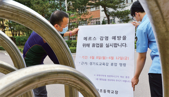 ▲ 경기도교육감 휴업명령에 따라 도내 일부지역 학교가 휴업에 들어간 8일 화성시 내 한 초등학교에서 선생님들이 교문에 휴업 연장 안내문을 내걸고 있다. 한편 휴업이 장기화 되면서 일선 학교들이 학사일정 조정문제로 또다른 골머리를 앓고 있다.   김시범기자